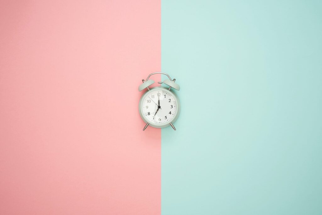 reloj sobre fondo azul y rosa cambio de hora