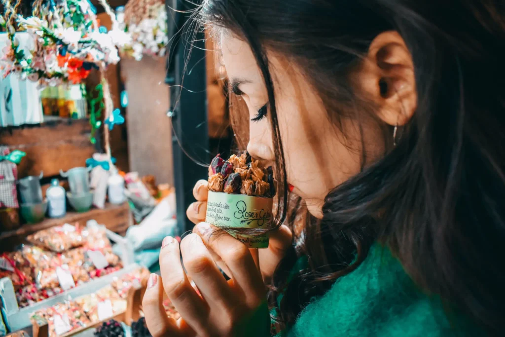 chica oliendo flores secas para aromatizar