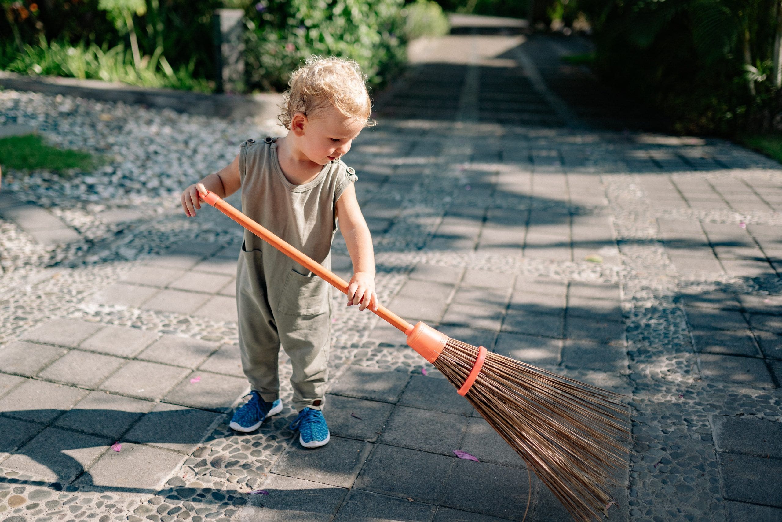 niño barriendo tareas del hogar en familia
